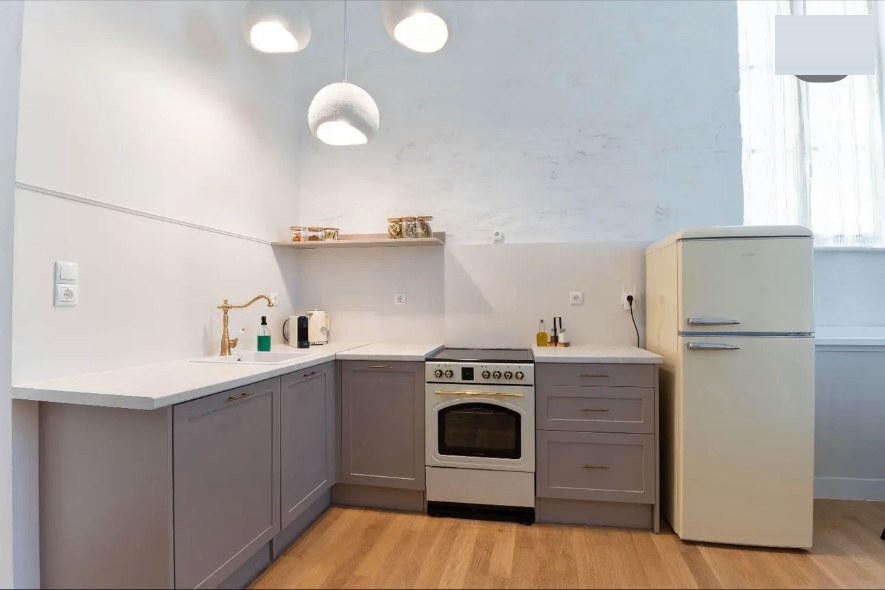 Aetheria kitchen with a cream refrigerator and brass tap