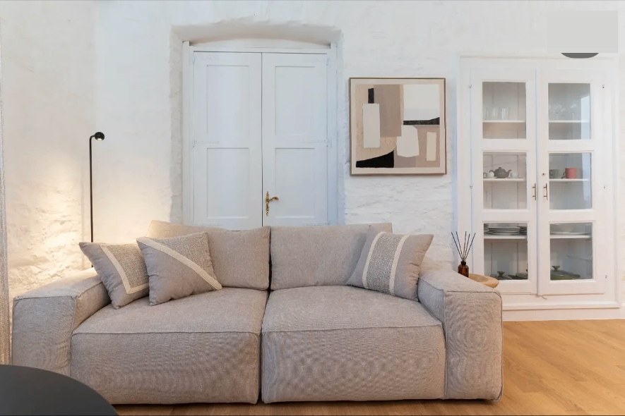 Aetheria living room with a linen sofa and glass cabinet