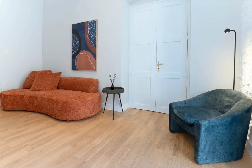 Living room terracotta curved sofa — Suite Amorosa at Syra di Giovanni 1862, Ermoupoli, Syros